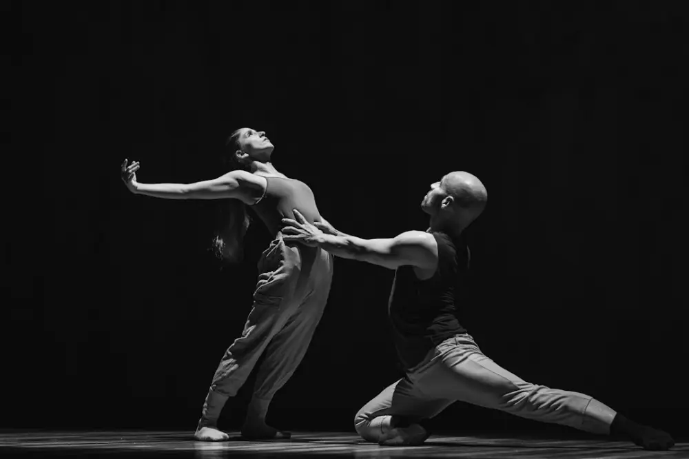 A couple of people standing on top of a dance floor, illustrating modern dance foundations